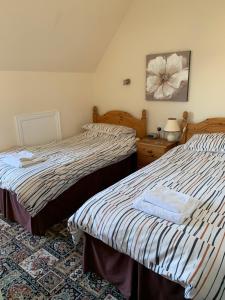 a bedroom with two beds and a table with a lamp at Kings Lodge Hotel in Great Yarmouth