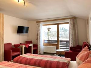 ein Hotelzimmer mit einem Bett, Stühlen und einem Fenster in der Unterkunft Haus Seerose in Bayerisch Gmain