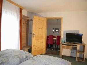 a bedroom with a bed and a desk with a television at Haus Seerose in Bayerisch Gmain