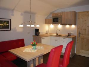 a kitchen with a wooden table and red chairs at Haus Seerose in Bayerisch Gmain