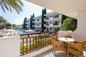 een balkon met een tafel en stoelen en een zwembad bij Inturotel Esmeralda Garden in Cala d´Or