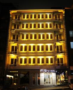 un edificio alto con luces encendidas delante de él en Grand Sera Hotel en Ankara