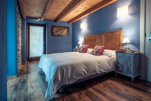 sypialnia z dużym łóżkiem z niebieskimi ścianami w obiekcie Rifugio Lilla w mieście La Thuile