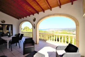 a balcony with a table and chairs and two windows at Holiday Home Impala in Jávea