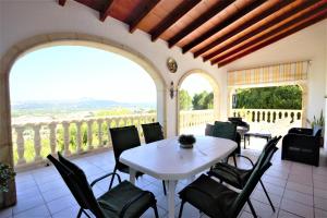 a dining room with a table and chairs on a balcony at Holiday Home Impala in Jávea