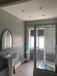 a bathroom with a glass shower and a sink at The Leam Hotel in Weymouth