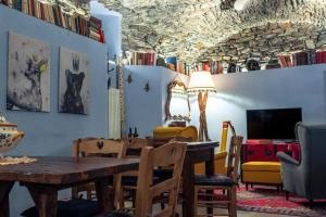 uma sala de jantar com mesa e cadeiras e um tecto cheio de livros em Rifugio Lilla em La Thuile