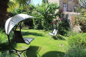 ogród z 2 krzesłami i parasolem w obiekcie Maison Prades Chambre d'Hôtes w mieście Prades