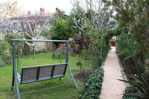 un columpio en un jardín junto a un camino en Maison Prades Chambre d'Hôtes en Prades