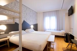 سرير أو أسرّة في غرفة في Hotel Urdanibia Park