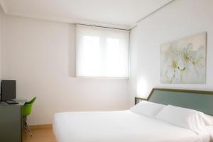 سرير أو أسرّة في غرفة في Hotel Urdanibia Park