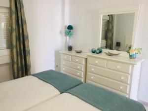 - une chambre avec un lit et une commode avec un miroir dans l'établissement VERDEMAR 39 MENYBER, à Nerja