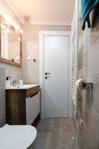 a bathroom with a toilet and a sink and a door at Kailani Luxury Central 3 Bedroom, 3 Bathroom Apartment With a Sunny Balcony in Zadar