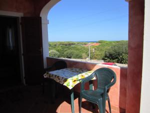 d'une table et de chaises sur un balcon avec vue. dans l'établissement casa rosa nel residence mirice con piscina ,wifi,climatizzatore - vicino al mare, à Aglientu