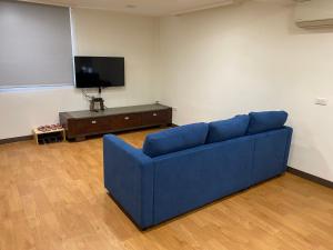南庄的住宿－南庄拾光民宿，客厅配有蓝色的沙发和电视