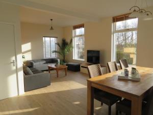 诺德克豪特Het Dijkstuk的客厅里有一张桌子和一张沙发