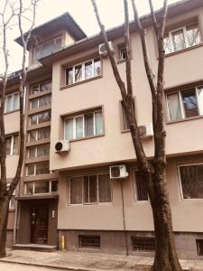 un edificio de apartamentos con ventanas y un árbol en Studio DOLCE VITA en Varna