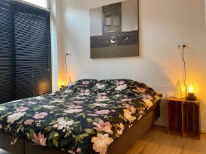 um quarto com uma cama com um edredão floral em Het Hoekje - 2 bedroom family friendly city home em Groningen