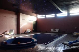 伊尔富德Boutique Hôtel palais Masandoia的一个带椅子的房间的大型游泳池