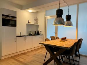 a kitchen with a table and chairs and a refrigerator at Het Hoekje - 2 bedroom family friendly city home in Groningen