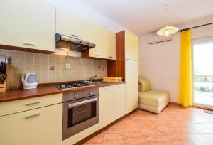 a kitchen with a stove top oven next to a window at Apartments Komadina 596 in Vlašići