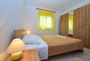 a bedroom with a bed and a lamp and a mirror at Apartments Komadina 596 in Vlašići