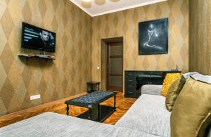 sala de estar con 2 sofás y TV en la pared en Alma Apartments, en Kiev