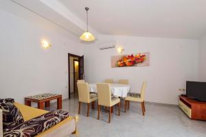 a dining room with a white table and chairs at Apartments Komadina 596 in Vlašići