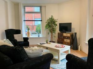 een woonkamer met stoelen en een televisie en een tafel bij Het Hoekje - 2 bedroom family friendly city home in Groningen