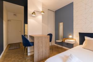 a bedroom with a bed and a desk and chairs at DIFY Charme - Bord du Rhone in Lyon