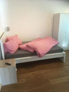 a bed with two pillows on it in a room at Apartments Carmena in Saas-Grund