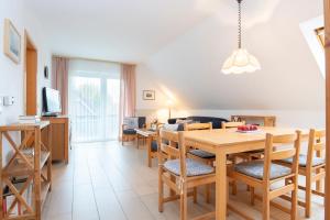 a dining room and living room with a table and chairs at Am Ganterhals 13 Wohnung 2 in Dahme