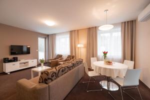 a living room with a couch and a table at Hotel Vila Viola in Luhačovice