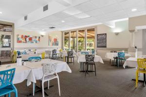 uma sala de jantar com mesas e cadeiras brancas em Econo Lodge Griffith Motor Inn em Griffith