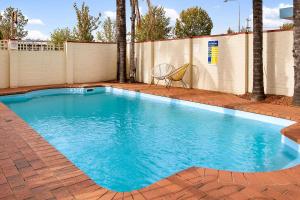 una piscina con agua azul en un patio trasero en Econo Lodge Griffith Motor Inn en Griffith