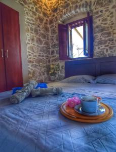 a tray with a cup and a plate on a bed at Sevi's Traditional House in Kalymnos