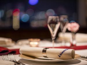 a table with a plate with a napkin and a glass of wine at Shibuya Excel Hotel Tokyu in Tokyo