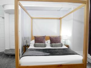 - une chambre avec un lit à baldaquin et 2 oreillers dans l'établissement Norton House Hotel - Mumbles, à Swansea