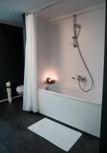 La salle de bains est pourvue d'une baignoire, d'une douche et de toilettes. dans l'établissement Smartflats Design - L42, à Bruxelles