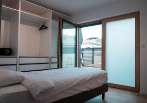 - une chambre avec un lit et des portes coulissantes en verre dans l'établissement Smartflats Design - L42, à Bruxelles