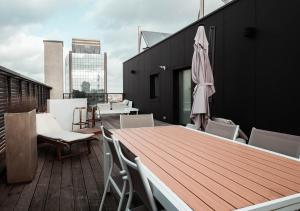 d'une terrasse sur le toit avec une table et des chaises en bois. dans l'établissement Smartflats Design - L42, à Bruxelles