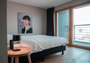 - une chambre avec un lit, une table et un tableau dans l'établissement Smartflats Design - L42, à Bruxelles