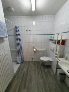 y baño con aseo y lavamanos. en Eden´s Ferienwohnungen, en Neuharlingersiel