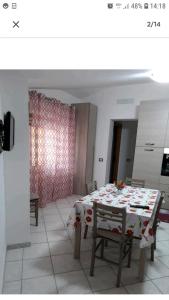 - une salle à manger avec une table, une table et des chaises dans l'établissement Appartamento Ariosto, à Bosa