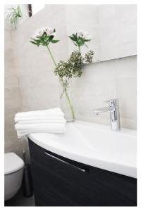 a bathroom with a sink with a vase of flowers at A Cjase di Lise in Gemona del Friuli