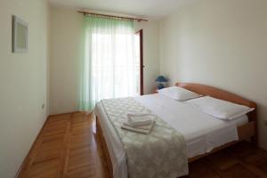 a bedroom with a large white bed and a window at Apartment Toni 555 in Primošten