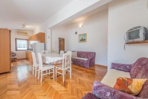 Apartments Ivić في Jadrtovac: غرفة معيشة مع طاولة وأريكة