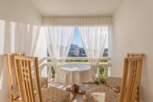 a room with a table and chairs and a window at Apartments Ivić in Jadrtovac