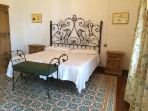 1 dormitorio con 1 cama blanca y 1 silla verde en Cortijo Los Monteros, en Benalup-Casas Viejas