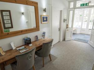 インバネスにあるDrumdevan Country House, Invernessの木製テーブル、椅子、鏡が備わる客室です。